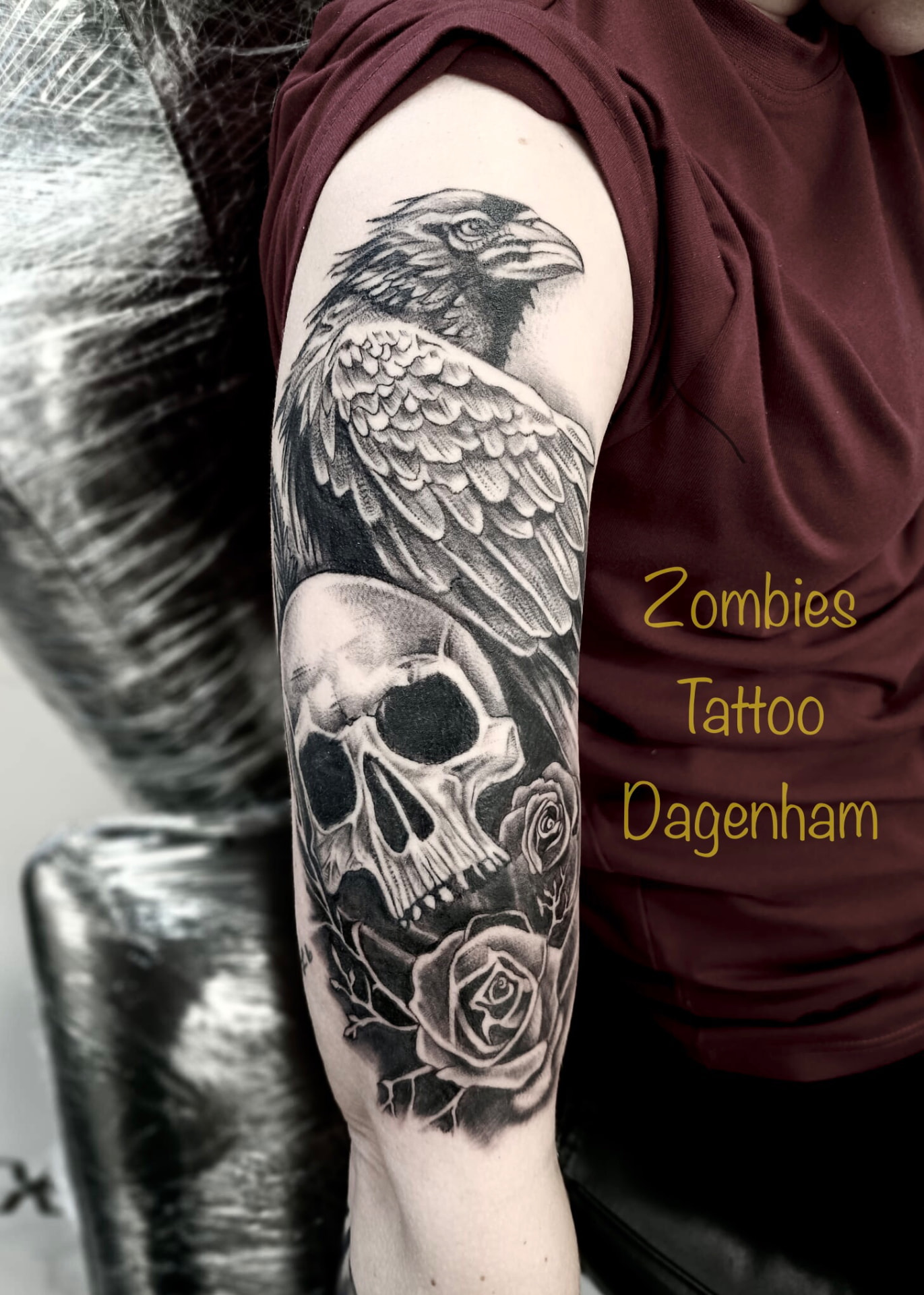 Black and grey raven, skull and roses upper-arm tattoo